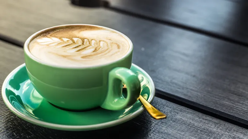 翠绿色的咖啡杯子卡布奇诺拉花咖啡