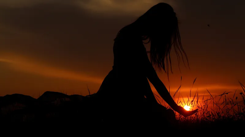 日落时女孩用手捧太阳秀出艺术