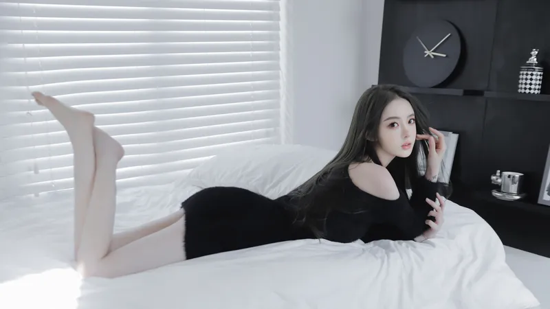 美女黑色毛衣连衣裙翘腿趴床上
