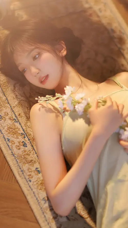 美女手捧鲜花躺在地垫上