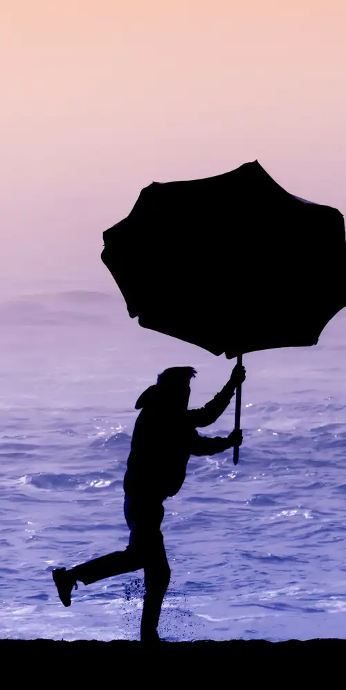 海滩上撑着伞的人的剪影