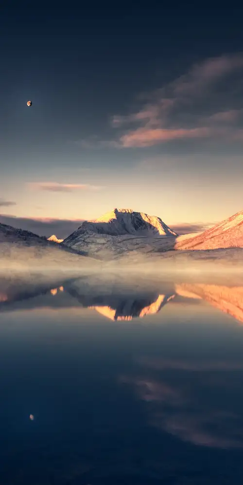 平静的湖泊被白雪覆盖的山脉环绕